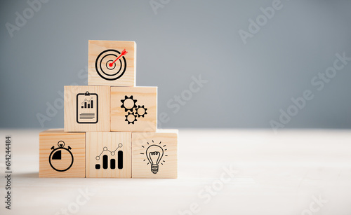 Business target concept on wooden block step. Action Plan and Goal icons symbolize success. Company strategy and project management on a table. Financial growth is the objective.