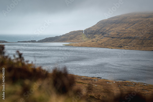 Lonely cottage next to Sørvágsvatn lake in Faroe Islands during cloudy day