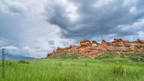 stormy clouds over sandstone cliff and green prairie in Colorado foothills - Lory State Park in late spring scenery