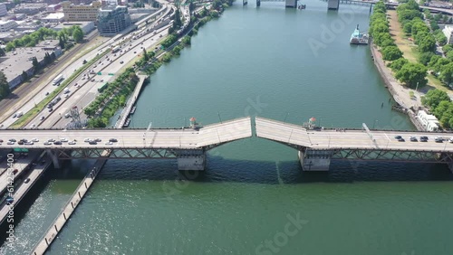 Portland Oregon, USA - steady flight above river Willamette with Burnside Bridge just closing the double-leafs bascule - traffic is still waiting - aerial cityscape, aerial video footage