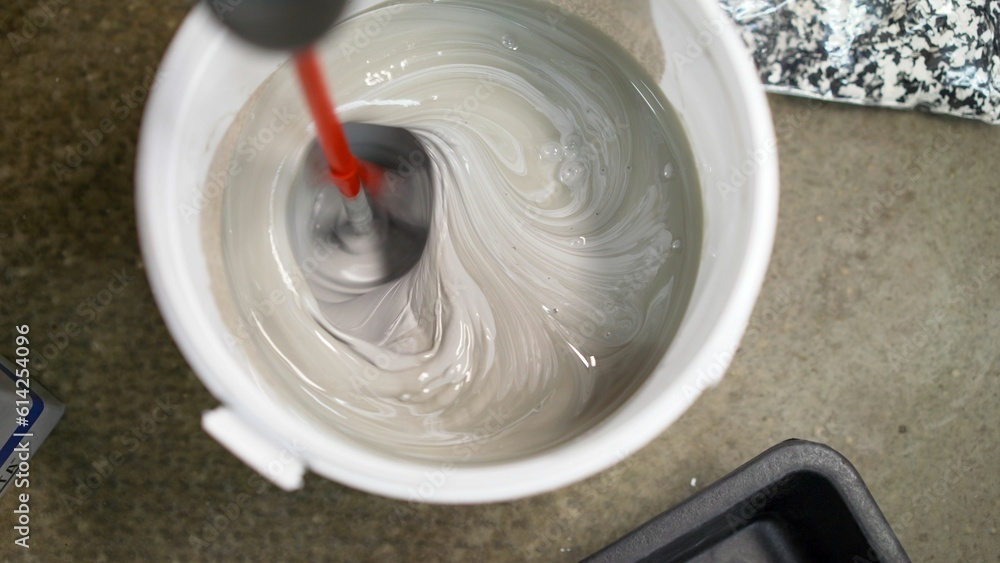 Close-up of mixing gray decorative concrete plaster. Gray decorative concrete plaster close-up. Mortar for decorative floors. Close-up of mixing gray decorative concrete plaster. Gray decorative concrete plaster close-up. Mortar for decorative floors.