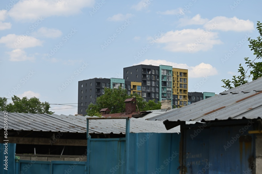 Almaty urban landscape with old house roofs and new buildings beside