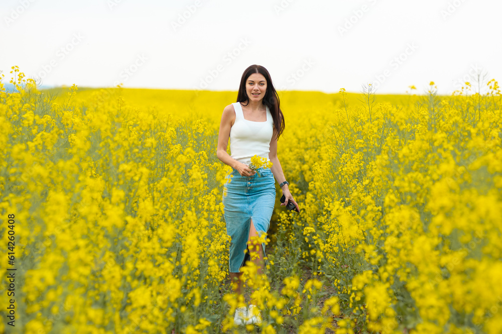 Happy beautiful woman walking on the field with yellow flowers Happy beautiful woman walking on the field with yellow flowers