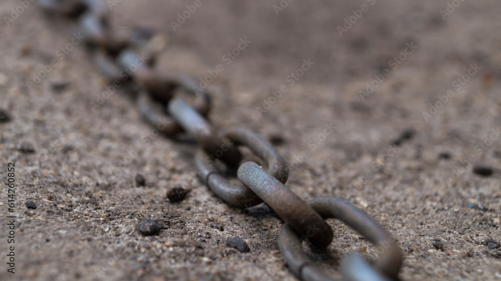 Iron chain. An iron flail lies on the ground. Old iron flail close-up Iron chain. An iron flail lies on the ground. Old iron flail close-up