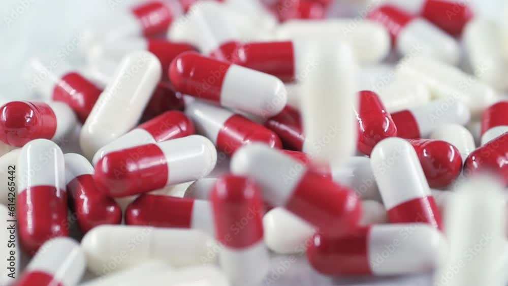 Capsule on a white background filled with medicine is in a chaotic order. Pills fall on the table. Capsule on a white background filled with medicine is in a chaotic order. Pills fall on the table.