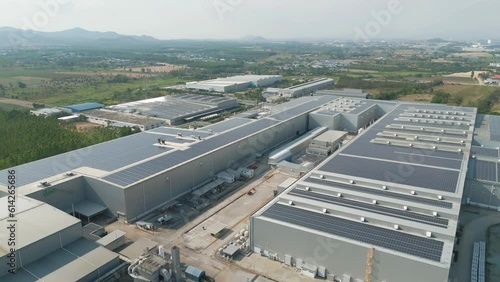 Aerial view of solar panels or solar cells on the roof of factory building rooftop. Power plant, renewable clean energy source. Eco technology for electric power in industry.