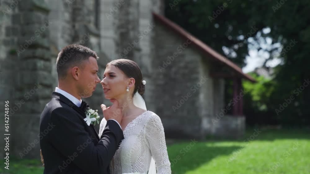 Newlyweds portrait. Lovely Caucasian bride, groom walking near old castle. Newlyweds portrait. Lovely Caucasian bride, groom walking near old castle.