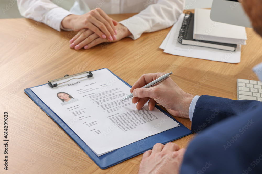 Human resources manager reading applicant's resume in office, closeup Human resources manager reading applicant's resume in office, closeup