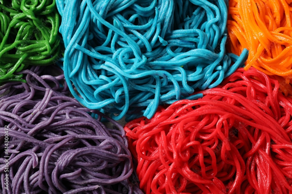 Rolled spaghetti painted with different food colorings as background, closeup Rolled spaghetti painted with different food colorings as background, closeup