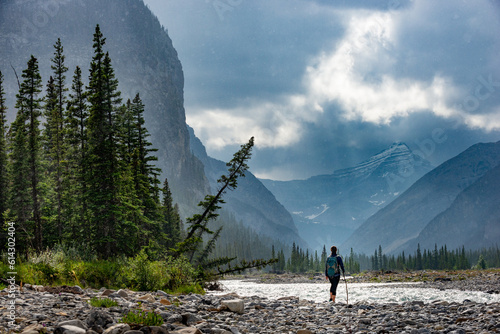Hiking in the rain Woman Hiker crosses the Ghost River Trans Alta trail with Mt Aylmer in the background photo
