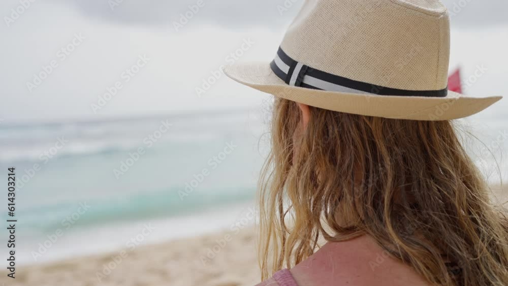 Adult girl in a straw hat sits on the ocean shore. Slow motion. Horizontal Video. 4K Adult girl in a straw hat sits on the ocean shore. Slow motion. Horizontal Video. 4K