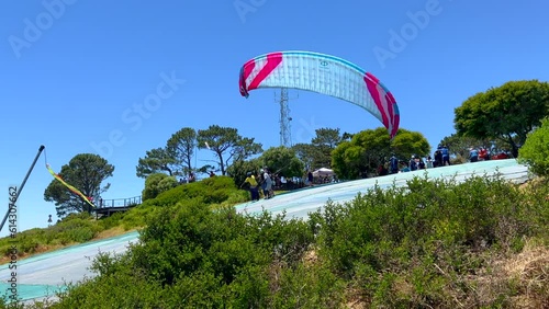Paragliding hang glide flying off Table Mountain Lions Head launch pad to Cape Town beach South Africa summer adventure beautiful calm wind still morning slow motion follow