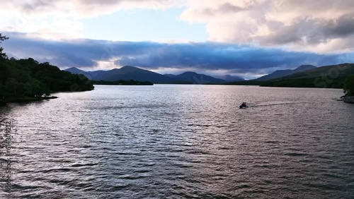 4K Aerial Angle Fly In Towards Speedboat on Loch Lomond Leaving Marina in Balmaha, Scotland photo