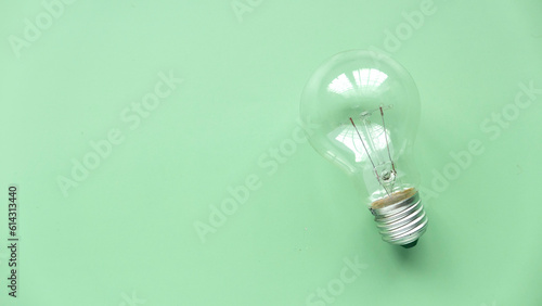 Top view of Light bulb on the green background.The concept of energy saving, renewable energy and environmentally friendly.Copy space.
