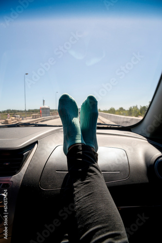 Feet on the dashboard of the car while traveling on route.