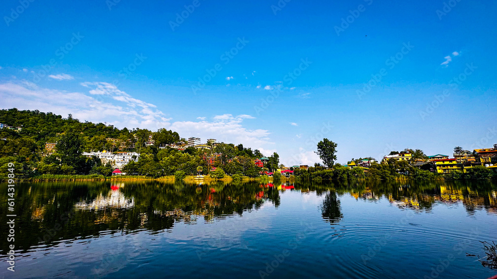 A beautiful landscape view of rewalsar lake with reflection of mountains.