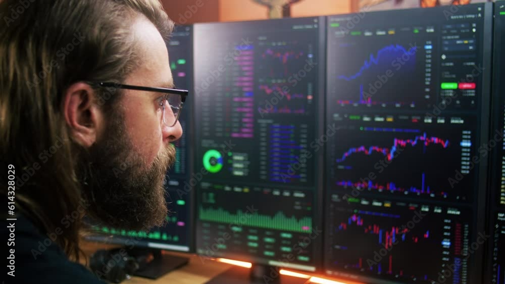 Focused trader, analyst looks at computer screen with multiple monitors, analyzes real-time stocks, exchange market charts. Man works remotely in investment at home office. Cryptocurrency trading. Focused trader, analyst looks at computer screen with multiple monitors, analyzes real-time stocks, exchange market charts. Man works remotely in investment at home office. Cryptocurrency trading.