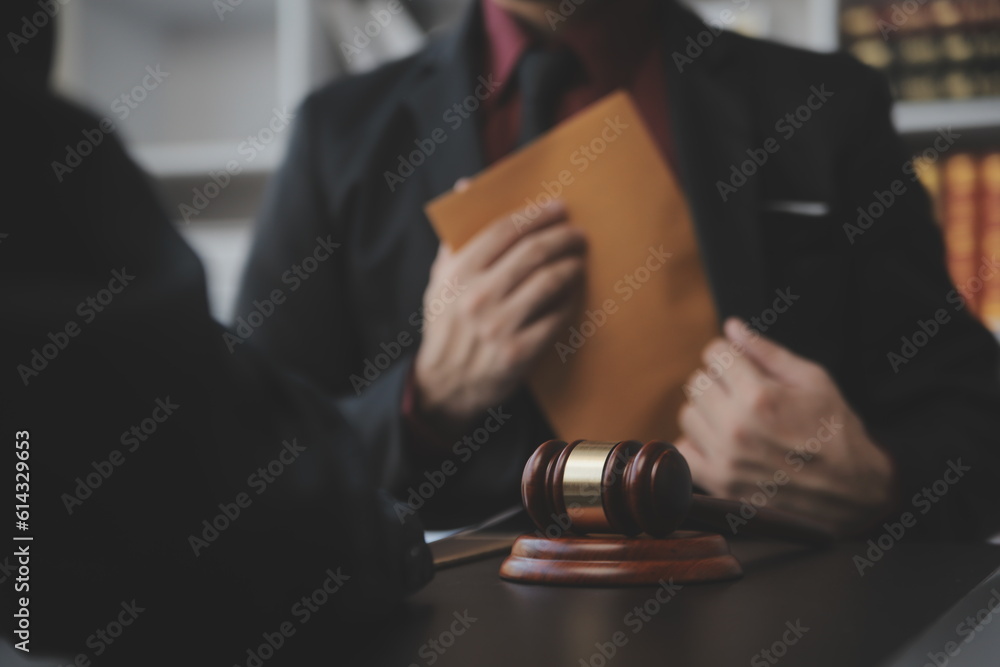 Justice and law concept.Male judge in a courtroom with the gavel, working with, computer and docking keyboard, eyeglasses, on table in morning light