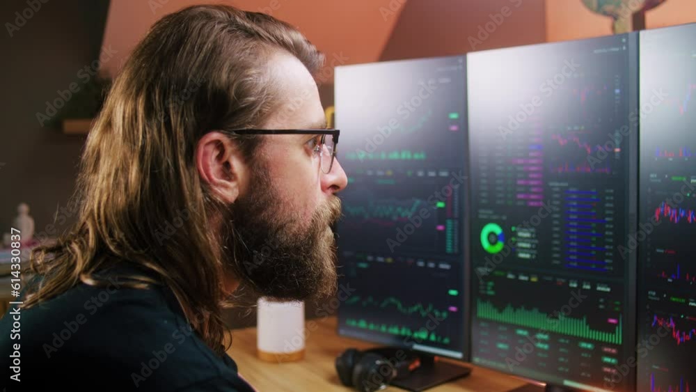 Concentrated male trader watches real-time stocks, exchange market charts on multi-monitor computer workstation. Man works remotely in investment at home office. Cryptocurrency trading. Close up. Concentrated male trader watches real-time stocks, exchange market charts on multi-monitor computer workstation. Man works remotely in investment at home office. Cryptocurrency trading. Close up.