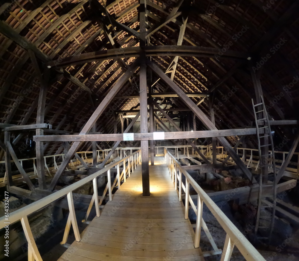 Fototapeta premium Wooden trusses supporting the roof of an old Gothic church, showcasing medieval engineering, craftsmanship, and the architectural ingenuity of historical Europe.