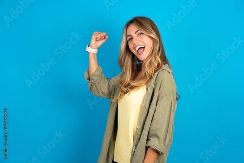 Profile side view portrait young beautiful blonde woman wearing overshirt celebrates victory