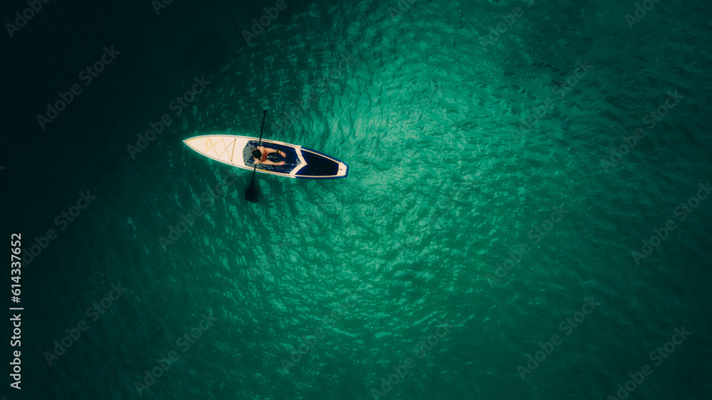 Aerial shot of beautiful green lagoon at hot summer day with small boat. Top view of girl in the boat. Aerial shot of beautiful green lagoon at hot summer day with small boat. Top view of girl in the boat.