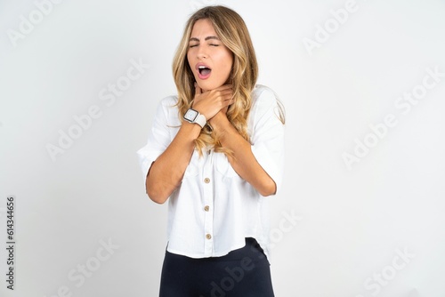 Slika na platnu Young caucasian business woman wearing white shirt over white background shouting suffocate because painful strangle