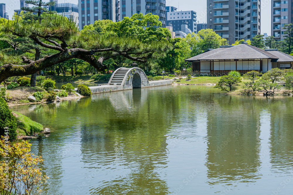 Naklejka premium Concrete bridge across lake at Shukkeien Gardens in Hiroshima.
