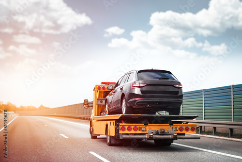 Reliable Towing and Recovery Services: 24/7 Assistance for Vehicle Breakdowns and Accidents. Emergency roadside assistance on the highway. side view of the flatbed tow truck with a damaged vehicle photo