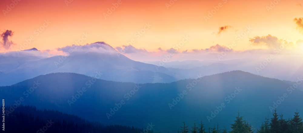 A majestic view of the mountain ranges illuminated by the sunset.