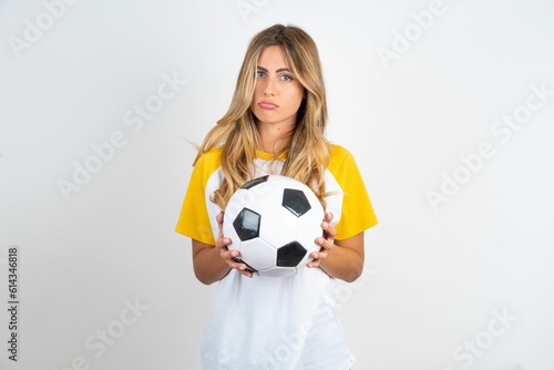 Young beautiful woman wearing football T-shirt over white background depressed and worry for distress, crying angry and afraid. Sad expression. © Jihan