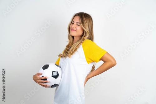 Young beautiful woman wearing football T-shirt over white background got back pain