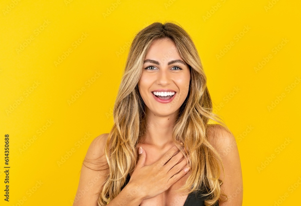 young beautiful blonde woman wearing bikini over yellow studio background smiles toothily cannot believe eyes expresses good emotions and surprisement young beautiful blonde woman wearing bikini over yellow studio background smiles toothily cannot believe eyes expresses good emotions and surprisement
