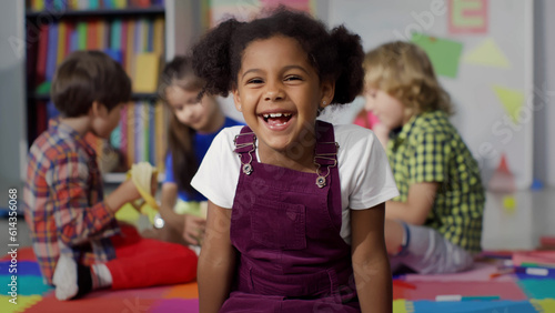 Close up portrait of smiling little African-American girl looking at camera at primary school