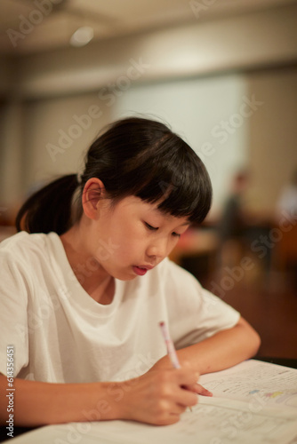 学校の自習室で宿題をしている小学生の女の子の様子