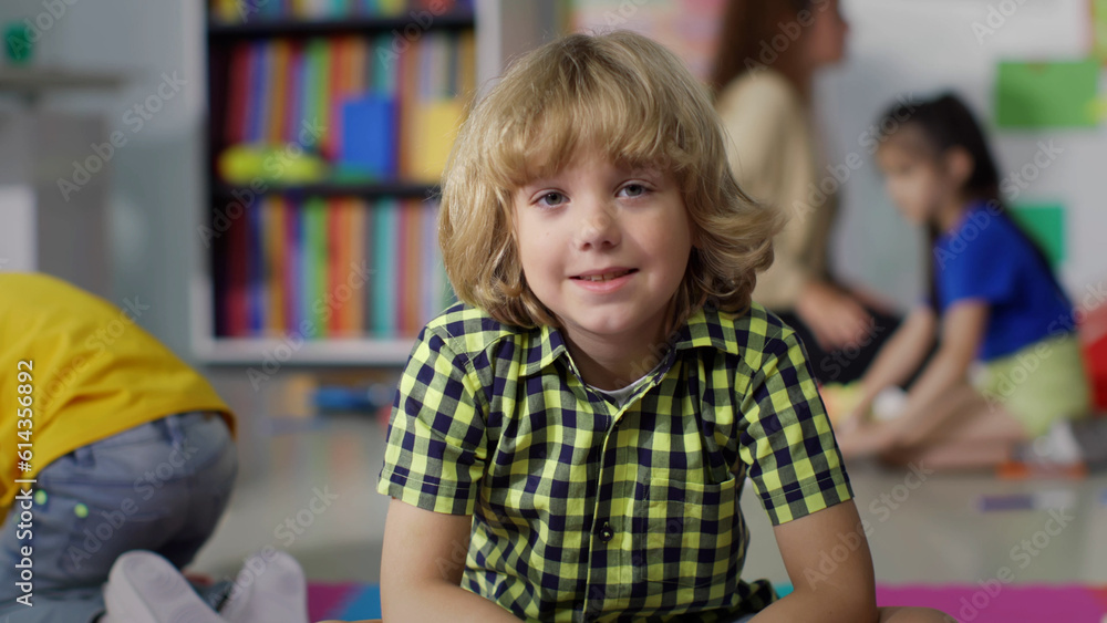 Portrait of adorable preschool boy smiling at camera in kindergarten Portrait of adorable preschool boy smiling at camera in kindergarten