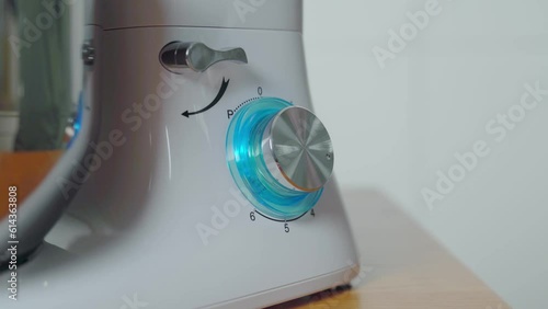 Hands turning speed dial on food processor kitchen appliance. Closeup photo