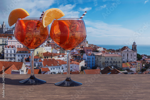 Two glasses of Spritz cocktail with view of Lisbon old town in Alfama district in Lisbon, Portugal