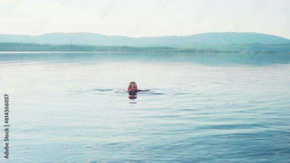 Man Swimming In Fjord In Trondelag, Norway. wide Man Swimming In Fjord In Trondelag, Norway. wide