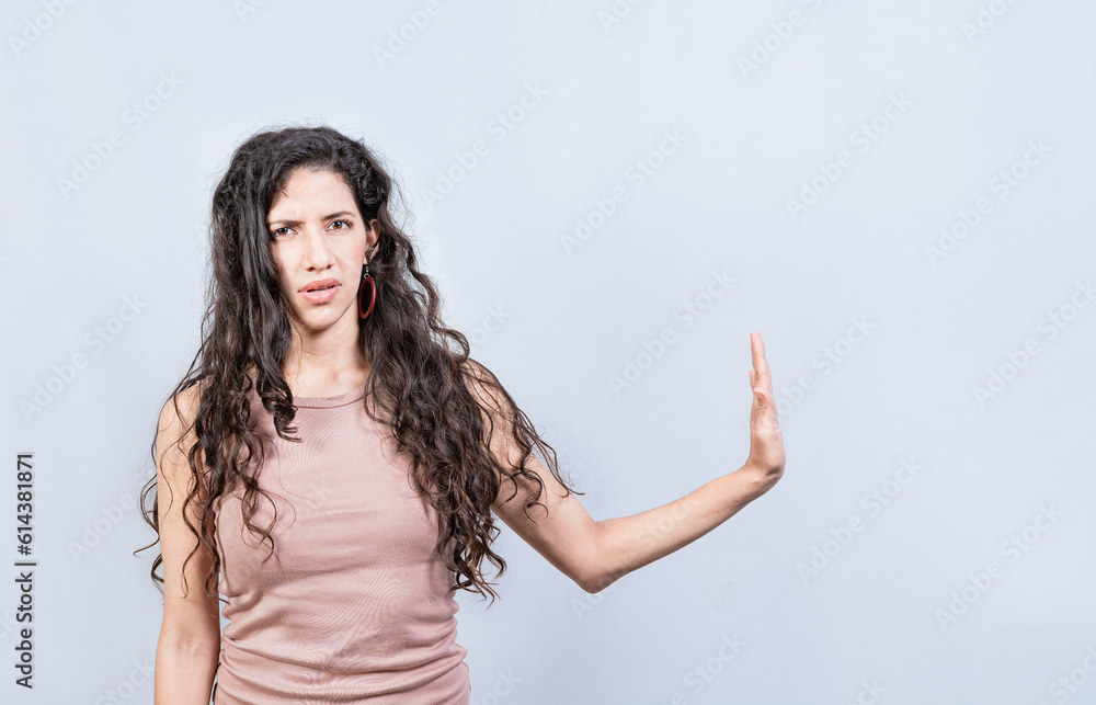 Displeased young woman rejecting with palm of hand isolated. Displeased girl making rejection gesture with palm of hand on white background. Displeased young woman rejecting with palm of hand isolated. Displeased girl making rejection gesture with palm of hand on white background.