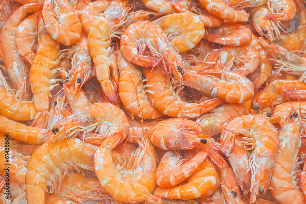 A close up shot showing a display of fresh, loose shrimp for sale in a supermarket. A close up shot showing a display of fresh, loose shrimp for sale in a supermarket.