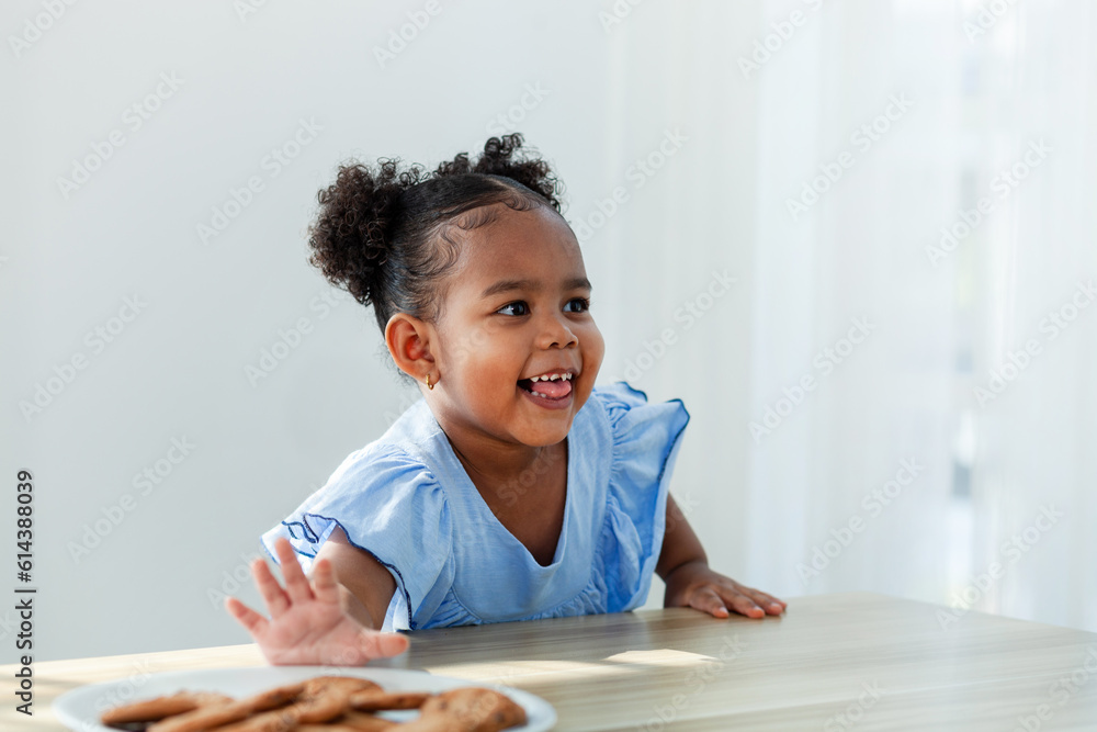 African American girl eating cookies expresses fear Afraid of the silence. while her parents are cooking. African American girl eating cookies expresses fear Afraid of the silence. while her parents are cooking.