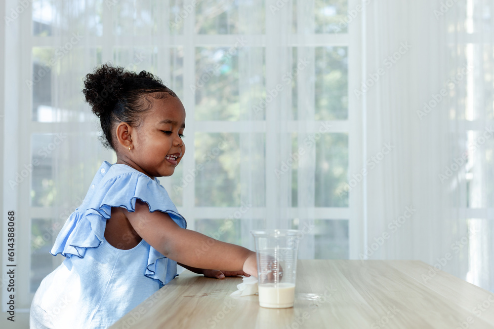 African little girl enjoy cleaning cover on the dining table African little girl enjoy cleaning cover on the dining table