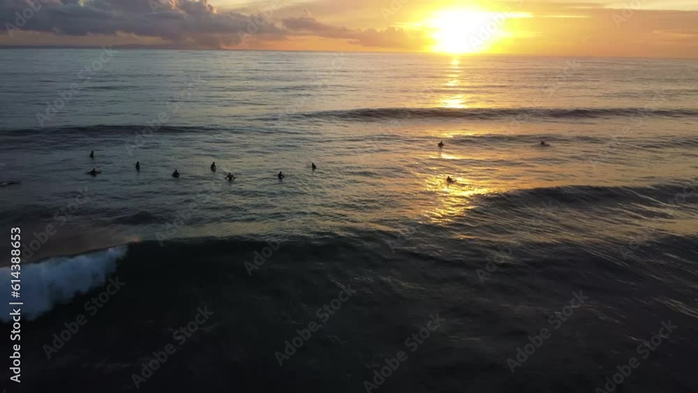 Group of surfer silhouette enjoying sunset in ocean water, aerial view Group of surfer silhouette enjoying sunset in ocean water, aerial view