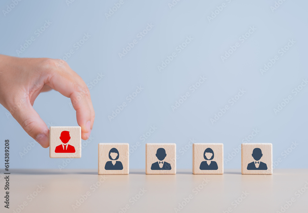 Hand holding a wooden cube red human icon with other wood blocks. Employee leader choice for the team. Leadership selection, Business hiring, Job recruitment. Career path opportunity. Human Resource. Hand holding a wooden cube red human icon with other wood blocks. Employee leader choice for the team. Leadership selection, Business hiring, Job recruitment. Career path opportunity. Human Resource.