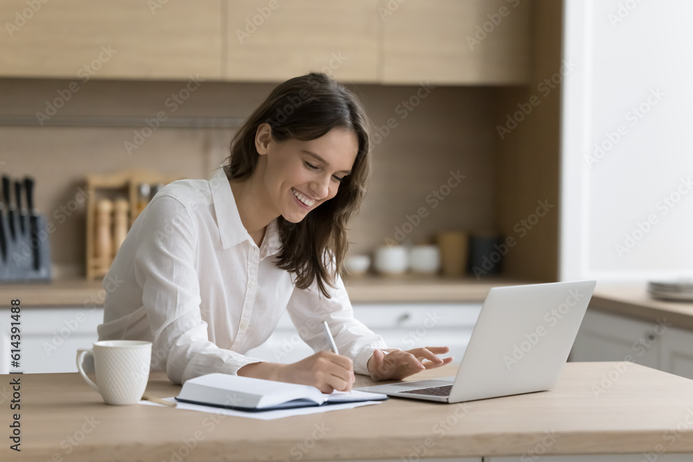 Woman write notes, planning workday and meeting in personal paper organizer sit at table with laptop. Studying use tech, freelancer workflow, create business to-do list, jotting important information Woman write notes, planning workday and meeting in personal paper organizer sit at table with laptop. Studying use tech, freelancer workflow, create business to-do list, jotting important information