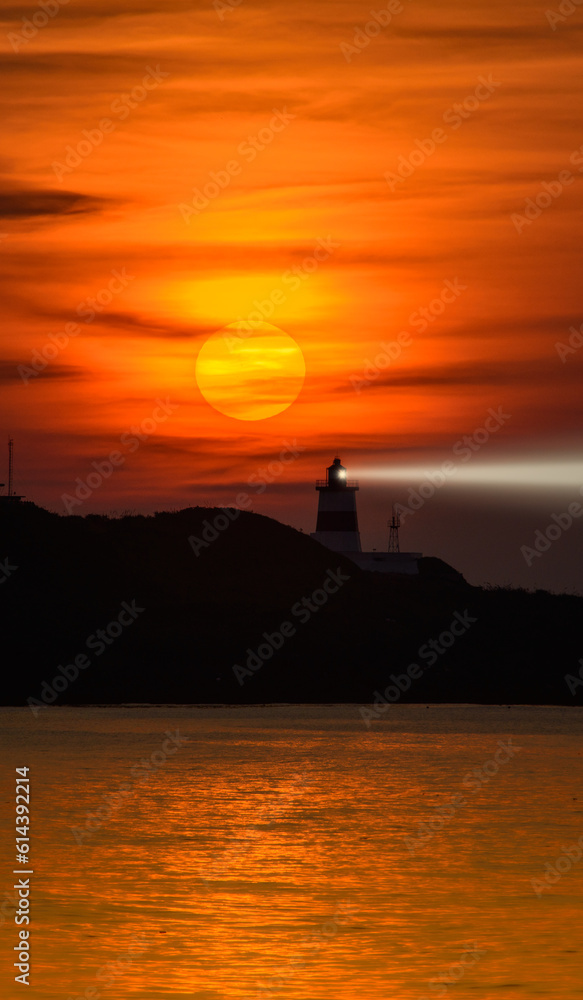At dusk, the sun is above the lighthouse. The Fugui Cape Lighthouse in Shimen. Taiwan