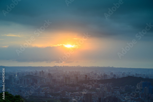 Rolling fast moving dark clouds. Orange sunset. At dusk, the view of Taipei City on a cloudy day.