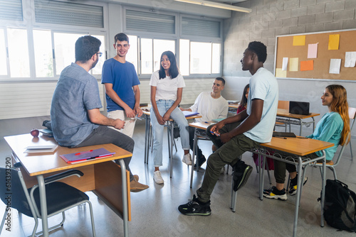 Fotografie, Obraz Students and young teacher having a conversation at classroom
