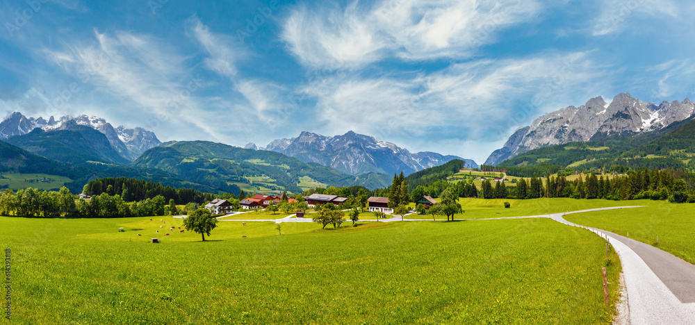 Summer Alpine mountain country panorama with grassy meadow and road to village (Austria) Summer Alpine mountain country panorama with grassy meadow and road to village (Austria)